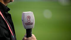 A journalist holds a mic during an England training session at Al Wakrah SC Stadium in Al Wakrah, south of Doha, on December 1, 2022, during the Qatar 2022 World Cup football tournament. (Photo by Nicolas TUCAT / AFP)