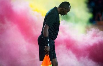 (FILES) In this file photo taken on May 25, 2019 a referee reacts wrapped in a cloud of smoke from flares thrown by fans during the CAF champion league final 2019