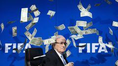 FIFA president Sepp Blatter looks on as fake dollar notes fly around him, thrown by a British comedian during a press conference at the FIFA world-body headquarter's in Zurich. -