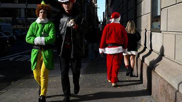 NEW YORK, NEW YORK - DECEMBER 10: People dressed in Santa Claus and elf costumes participate in SantaCon on December 10, 2021 in New York City. SantaCon is an annual Christmas themed pub crawl that raises money for charity. This year, SantaCon created a map and partnered with the app, Wolfie, that display real time updates about the lines, venues, and even friends’ locations. (Photo by Alexi Rosenfeld/Getty Images)