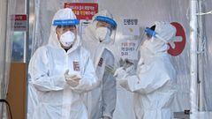 Health workers wearing protective gear stand at a Covid-19 coronavirus testing centre in Seoul on February 10, 2022, after South Korea&#039;s daily Covid-19 infections rose sharply to hit new high of over 50,000.