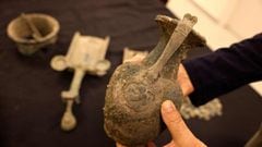 Uzi Rotstein, inspector in the The Prevention Unit at Israel Antiquities Authority, displays a bronze jug, one of a number of artifacts seized from antiquities dealers, bearing a depiction of a Roman banquet, consistng of a scene showing a reclining figur