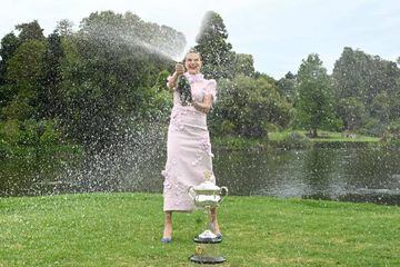 Aryna Sabalenka abriendo una botella de champán agitada durante la sesión de fotos como campeona del Abierto de Australia en los Jardines Reales de Melbourne.