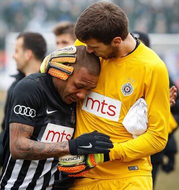 Partizan Belgrade's goalkeeper Filip Kljajic (R) hugs Brazilian midfielder Everton Luiz as he leaves the field in tears on February 19, 2017, at the end of a Serbian championship match between Partizan and Rad, after racist remarks from Rad's supporters,