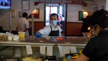 A server at The Original Ninfa&#039;s wears gloves and a mask while bringing takeout orders to the kitchen amid the novel coronavirus pandemic on May 1, 2020 in Houston, Texas. - Texas on Friday became the largest US state to begin easing coronavirus lock