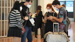Passengers look at smartphones at the arrival lobby of Haneda Airport in Tokyo, Japan, on Tuesday, Oct. 11, 2022. Japan began accepting vaccinated visitors from 68 countries without visas Tuesday, ending almost three years of tighter border controls that kept tourists out of the island nation. Photographer: Toru Hanai/Bloomberg via Getty Images