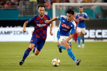 Napoli's Lorenzo Insigne (R) battles for the ball with Barcelona's Ivan Rakitic during the International Champions Cup football match between FC Barcelona and SSC Napoli at Hard Rock Stadium in Miami, Florida, on August 7, 2019. 