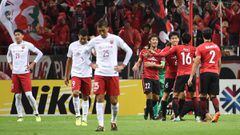 Los jugadores del Urawa Reds celebran el pase a la final de la Champions asi&aacute;tica ante los cabizbajos jugadores del Shanghai SIPG.