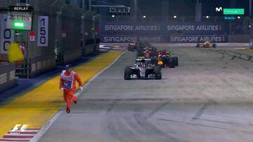 Un comisario esquiva a los coches de F1 en Singapur