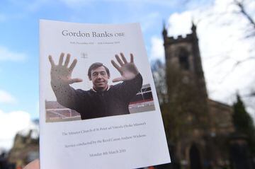 A man poses holding an order of service for the funeral service of Stoke City and England's former goalkeeper Gordon Banks outside Stoke Minster in Stoke-on-Trent.