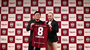 Spanish football star Andres Iniesta (R) and Hiroshi Mikitani, owner of Rakuten and Vissel Kobe club, hold Iniesta&#039;s new jersey during a press conference in Tokyo on May 24, 2018. / AFP PHOTO / Behrouz MEHRI