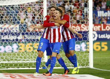 Gameiro (centre) is mobbed after seemingly winning the points for Atlético.