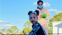 Serena Williams observa a su hija Alexis Olympia mientras golpea una bola de tenis con una raqueta.
