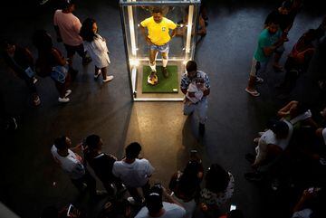 La gente se para junto a una escultura de cera de la leyenda del fútbol brasileño Pelé en el Museo Pelé en Santos, Brasil. 