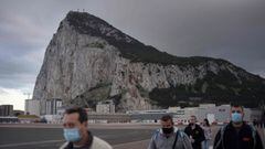 People cross the Spanish border of the British overseas territory of Gibraltar on November 24, 2020. - With its traditional British red phone boxes, pubs serving fish-and-chips and tax-free shopping, Gibraltar has long drawn day trippers from neighbouring