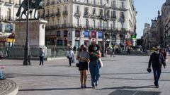 Transe&uacute;ntes pasean por la Puerta del Sol donde agentes de Polic&iacute;a Nacional permanecen en las inmediaciones realizando controles, en Madrid (Espa&ntilde;a), a 9 de octubre de 2020. El Ministerio del Interior ha comenzado a desplegar un amplio