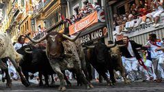 Participants run next to Fuente Ymbro fighting bulls on the fourth bullrun of the San Fermin festival in Pamplona, northern Spain on July 10, 2018. Each day at 8am hundreds of people race with six bulls, charging along a winding, 848.6-metre (more than h