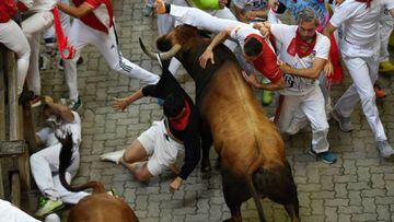Participants fall down next to Jose Cebada Gago bulls during the fifth "encierro" (bull-run) of the San Fermin festival in Pamplona, Spain.
