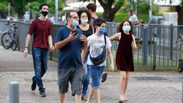 Personas con m&aacute;scaras protectoras debido a la pandemia de Covid-19, caminan en la ciudad costera israel&iacute; de Tel Aviv el 12 de julio de 2020.