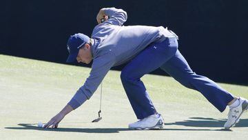 Jordan Spieth of the US picks up his ball on the fifth hole during the third round of the 2016 Masters Tournament at the Augusta National.