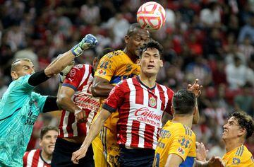 Jesus Orozco (3-R) of Guadalajara vies for the ball with Tigres' Argentine goalkeeper Nahuel Guzman (L) and defender Samir (C, top), during their Mexican Apertura football tournament match, at the Akron stadium in Guadalajara, Jalisco State, Mexico, on September 13, 2022. (Photo by Ulises RUIZ / AFP)
