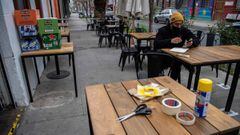 An employee sits at a table at a restaurant preparing to reopen as Chile&#039;s government allowed outdoor servicing in restaurants after easing some lockdown measures put into force amid the new coronavirus pandemic, in Santiago, on September 01, 2020. - Bars and restaurants - only outdoors - and other non-essential businesses will be able to open in several of the wealthiest neighborhoods of Santiago, Chilean health authorities confirmed Sunday, taking a step forward to the deconfinement of the capital, over five months after their closure due to the new coronavirus outbreak. (Photo by Martin BERNETTI / AFP)