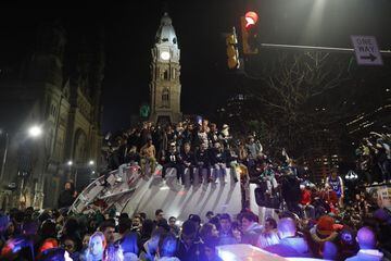 Seguidores de los Philadelphia Eagles celebran sobre un camión de basura el título de la NFL logrado por su equipo.