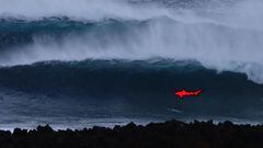 El bodysurfer Ahmed Erraji, Hijo del Mar, entre olas gigantes en La Santa (Lanzarote, Canarias, Espa&ntilde;a), con la presencia de un tibur&oacute;n y las rocas en primer plano. 