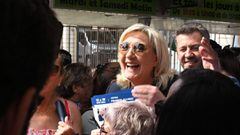 French far-right party Rassemblement National (RN) leader Marine Le Pen (C) meets people in an open air market in Marignane, near Marseille, while campaigning to support the candidacy of Franck Allisio (R) in the 12th constituency of the Bouches-du-Rhone 