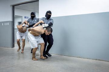 Agentes del Centro de Confinamiento del Terrorismo trasladan a un preso.