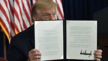El presidente Donald Trump firma una orden ejecutiva durante una conferencia de prensa en el Trump National Golf Club en Bedminster, Nueva Jersey, el s&aacute;bado 8 de agosto de 2020.