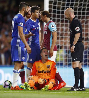Referee Anthony Taylor looks on as West Ham's Adrian reacts after a tackle with Chelsea's Diego Costa. No action taken.