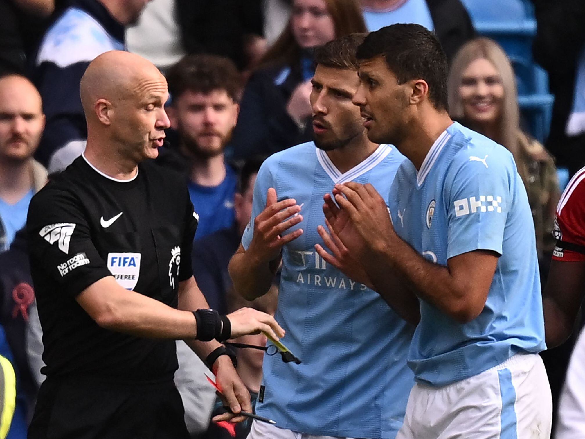 Manchester City's Spanish midfielder #16 Rodri (2R) appeals to English referee Anthony Taylor (L) having been shown a red card during the English Premier League football match between Manchester City and Nottingham Forest at the Etihad Stadium in Manchester, north west England, on September 23, 2023. (Photo by Oli SCARFF / AFP) / RESTRICTED TO EDITORIAL USE. No use with unauthorized audio, video, data, fixture lists, club/league logos or 'live' services. Online in-match use limited to 120 images. An additional 40 images may be used in extra time. No video emulation. Social media in-match use limited to 120 images. An additional 40 images may be used in extra time. No use in betting publications, games or single club/league/player publications. / 