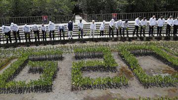 Leaders plant their seedlings during a mangrove planting event at the Tahura Ngurah Rai Mangrove Forest Park as part of the G20 Leaders' Summit in Nusa Dua.