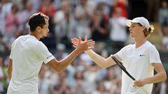 Italy's Jannik Sinner (R) shakes hands with Colombia's Daniel Elahi Galan after winning their men's singles tennis match on the seventh day of the 2023 Wimbledon Championships at The All England Tennis Club in Wimbledon, southwest London, on July 9, 2023. (Photo by Glyn KIRK / AFP) / RESTRICTED TO EDITORIAL USE