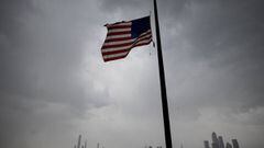 An US flag  flies at half-mast half mast in front of the Skyline of Manhattan of New York City seen from Weehawken, New Jersey, on April 21, 2020. - Over 2.5 million people have been confirmed to have contracted the coronavirus worldwide, with 80 percent 