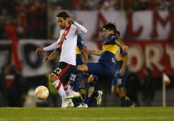 Pablo Pérez busca robar el balón a Leonardo Ponzio de River Plate.