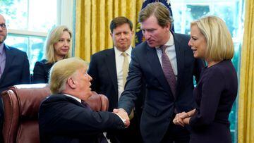 FILE PHOTO: U.S. President Donald Trump shakes hands with Chris Krebs, the director of the Cybersecurity and Infrastructure Security Agency (CISA) as DHS Secretary Kirstjen Nielsen (R) looks on after a signing ceremony for the Cybersecurity and Infrastruc