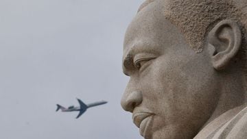 A plane flies behind the Stone of  Hope, a granite statue of civil rights leader Martin Luther King Jr., stands at his memorial in Washington, DC, on January 14, 2022. - Martin Luther King Day, which celebrates the January 15, 1929, birth of the civil rights icon, falls on January 17, 2022. (Photo by MANDEL NGAN / AFP)