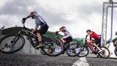 Varios ciclistas con sus E-MTB pasando por la l&iacute;nea de salida de una prueba de la Copa del Mundo UCI 2022. 