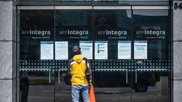 A man looks for information at the front door of Integra AFP (Pension Fund Administration) office in Lima on May 18, 2020. - More than six million Peruvians can request as of Monday the withdrawal of up to 3,700 US dollars from their pension funds to alleviate the economic crisis caused during the  two months lockdown imposed by the government to fight the spread of the novel Covid-19 coronavirus. (Photo by Ernesto BENAVIDES / AFP)