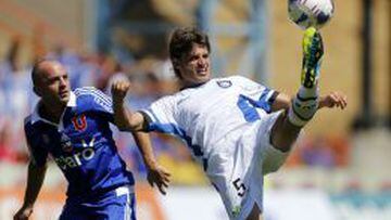 Merlo despeja el bal&oacute;n ante Lorenzetti en el duelo contra la U, en el Estadio CAP.
