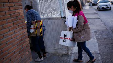 An electoral worker carries a box with voting materials to deliver it to a woman who was selected by the National Electoral Institute (INE) to act as a president of a polling station, for the recall referendum on President Andres Manuel Lopez Obrador, which will be held on April 10, in Ciudad Juarez, Mexico April 5, 2022. REUTERS/Jose Luis Gonzalez