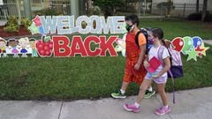 ARCHIVO - En esta foto de archivo del martes 10 de agosto de 2021, estudiantes con m&aacute;scaras protectoras pasan frente a un letrero de &quot;Bienvenida de regreso&quot; antes del primer d&iacute;a de clases en la escuela primaria Sessums en Riverview, Florida. 