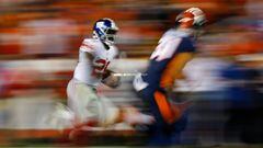 DENVER, CO - OCTOBER 15: Running back Orleans Darkwa #26 of the New York Giants runs with the football for a long gain as strong safety Justin Simmons #31 of the Denver Broncos defends during the second quarter at Sports Authority Field at Mile High on October 15, 2017 in Denver, Colorado.   Justin Edmonds/Getty Images/AFP == FOR NEWSPAPERS, INTERNET, TELCOS &amp; TELEVISION USE ONLY ==