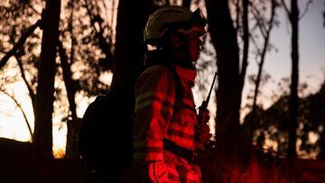A firefighter observes the fire during emergency response to extinguish a forest fire on a hill in Bogota, Colombia January 24, 2024. REUTERS/Antonio Cascio