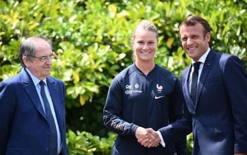French President Emmanuel Macron (R) shakes hands with France's midfielder and captain Amandine Henry (C) flanked by FFF president Noel le Graet (L) in Clairefontaine-en-Yvelines, southwest of Paris, on June 4, 2019 during the French women national footba