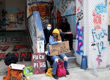 Protesters sit in front of an entrance of Seattle Police Department East Precinct at the self-proclaimed Capitol Hill Autonomous Zone (CHAZ) during a protest against racial inequality and call for defunding of Seattle police, in Seattle, Washington.