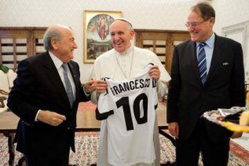 El Papa Francisco sonríe mientras recibe una camiseta, con el presidente de la FIFA, Joseph Blatter durante una audiencia privada en el Vaticano