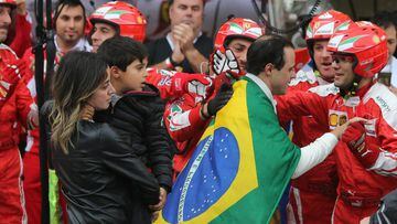 Tearful Williams Martini Racing&#039;s Brazilian driver Felipe Massa, wrapped in his country&#039;s flag, is followed by his wife and son as he is greeted by members of the Ferrari team after he crashed out of his home Brazilian Grand Prix in his final ap